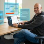 Solopreneur arbeitet konzentriert am Laptop mit sichtbaren KI-Tool-Interfaces, Automation Flows und Checklisten im Home